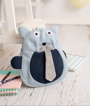 Children's backpack shaped like a castor with a tie on a wooden surface.