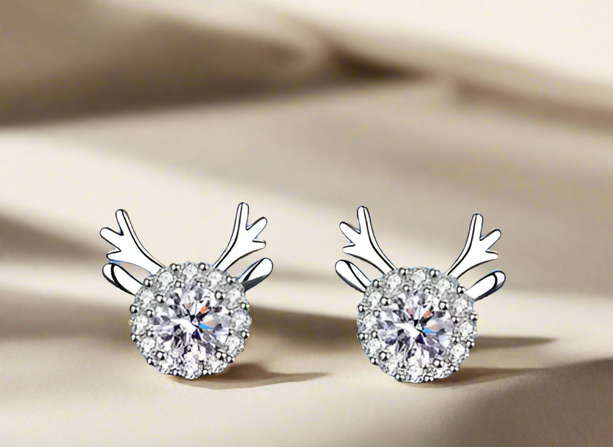 A pair of sterling silver stud earrings featuring a deer design, with the earrings having a shiny finish and adorned with small crystals.
