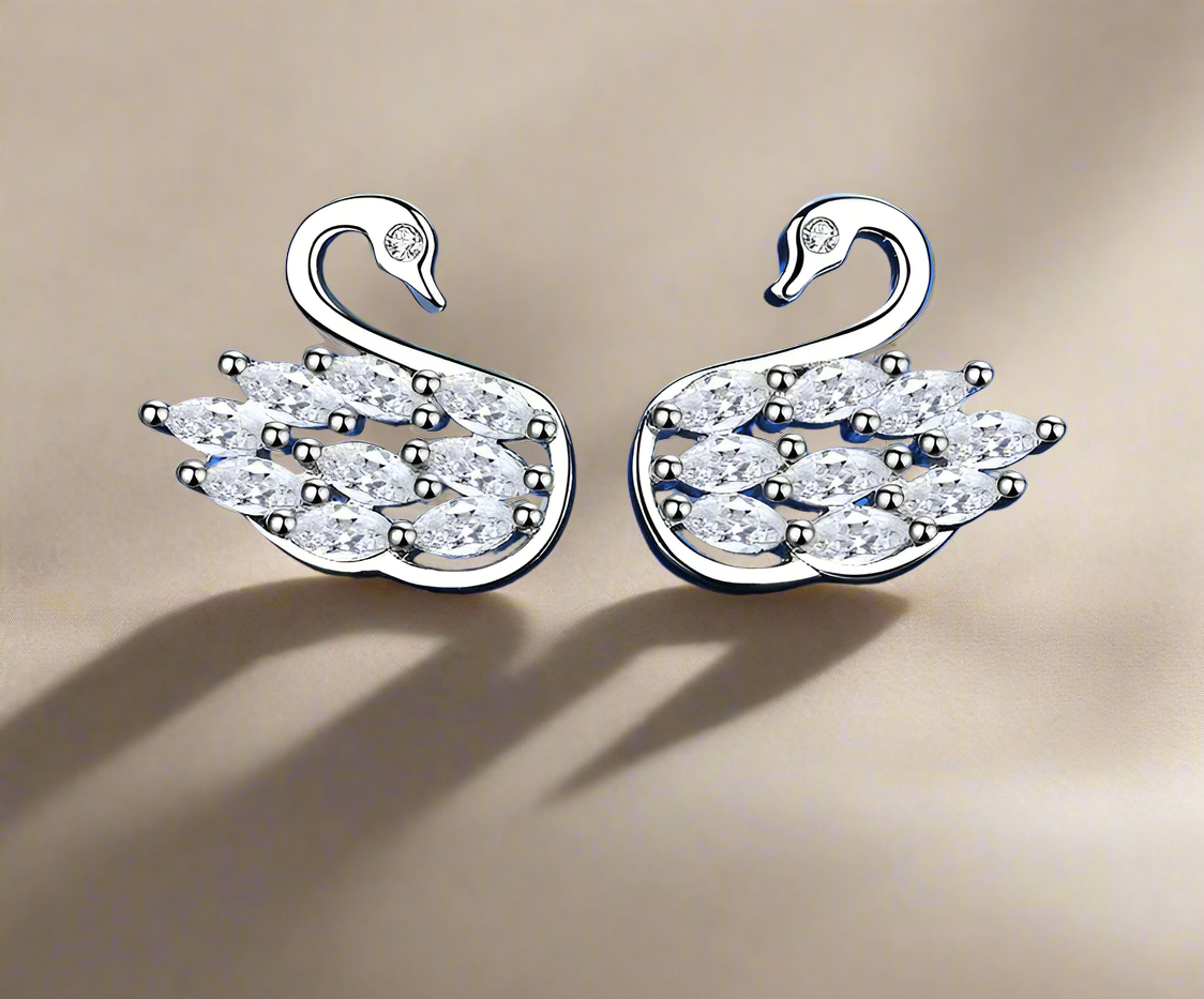 A pair of sterling silver stud earrings featuring a swan design with inset stones.